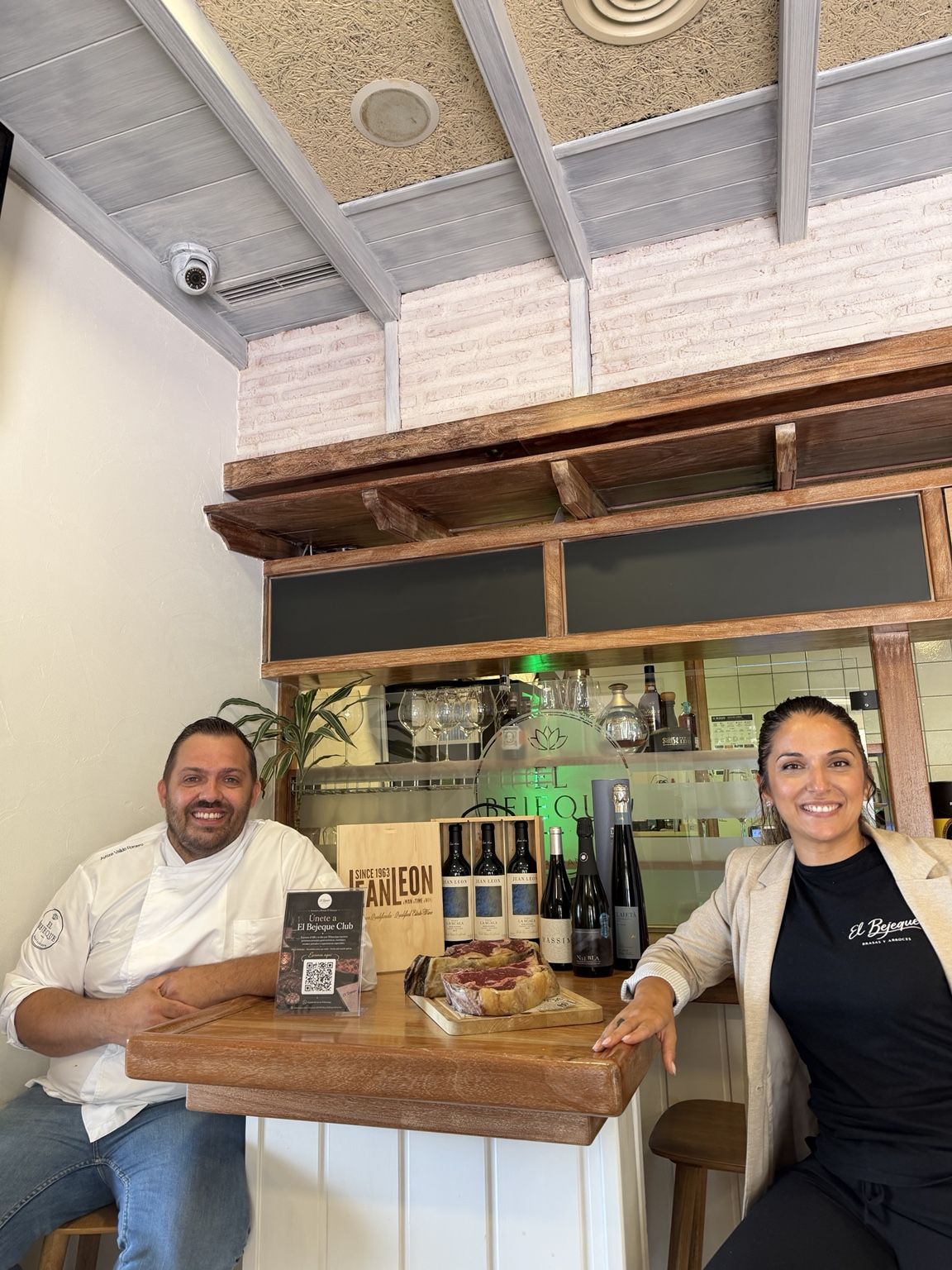 Ayoze Valido y Kiara León en la barra del restaurante, con vinos y una carne madurada
